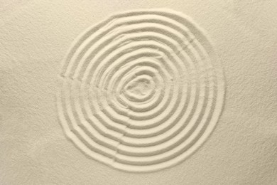 Photo of Beautiful spiral on sand, top view. Zen garden