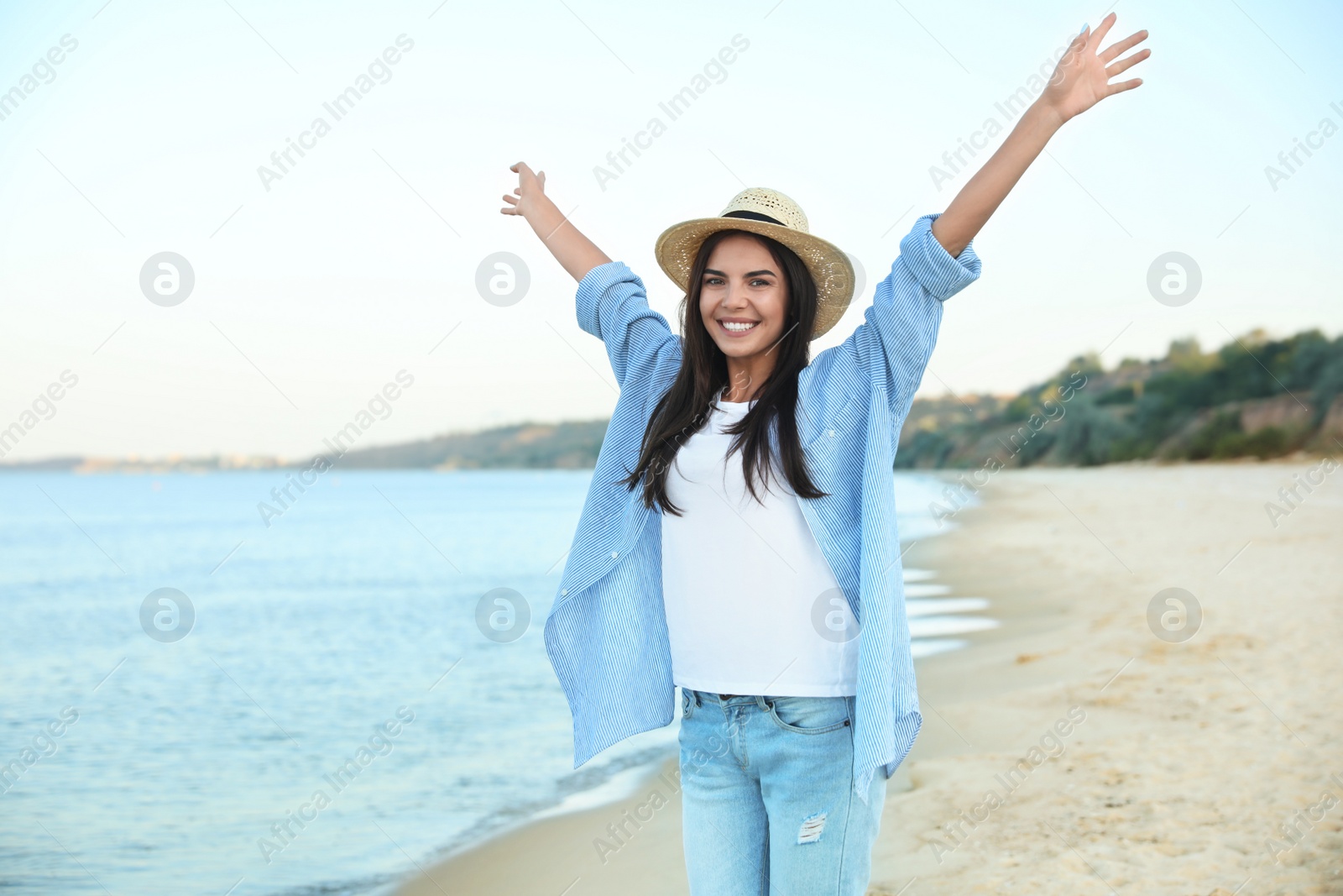 Photo of Beautiful young woman in casual outfit on beach