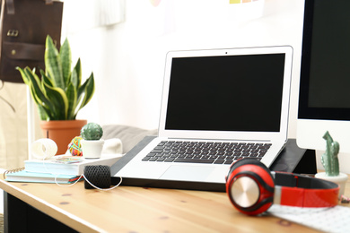 Modern laptop, computer and office supplies on wooden table, space for text. Designer's workplace