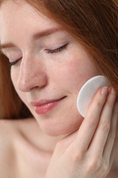 Photo of Beautiful woman with freckles wiping face, closeup