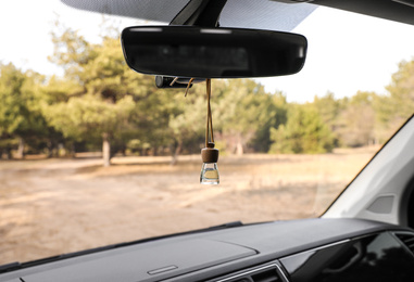 Photo of Air freshener hanging on rear view mirror in car