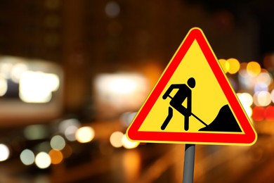 Image of Traffic sign Road Works on city street in night. Bokeh effect