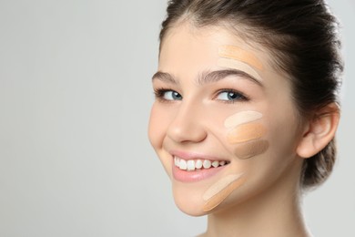 Photo of Beautiful girl on light grey background. Using concealers and foundation for face contouring
