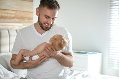 Photo of Father with his newborn son at home