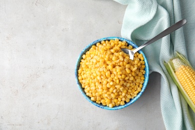 Flat lay composition with corn kernels in bowl on grey background. Space for text