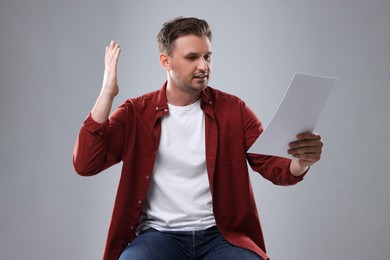 Photo of Casting call. Man with script performing against light grey background