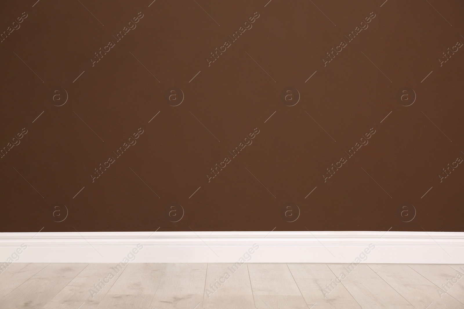 Photo of Empty room with wooden floor and brown wall. Interior design