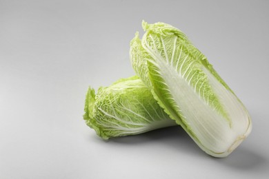 Photo of Fresh ripe Chinese cabbages on light grey background. Space for text