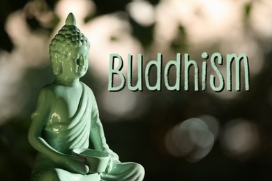 Image of Decorative Buddha statue and word Buddhism on blurred background