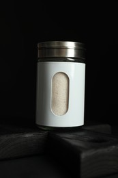 Photo of Salt shaker on table against black background