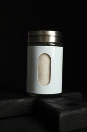 Salt shaker on table against black background