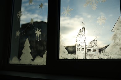 Beautiful drawing made with artificial snow on window. Christmas decor