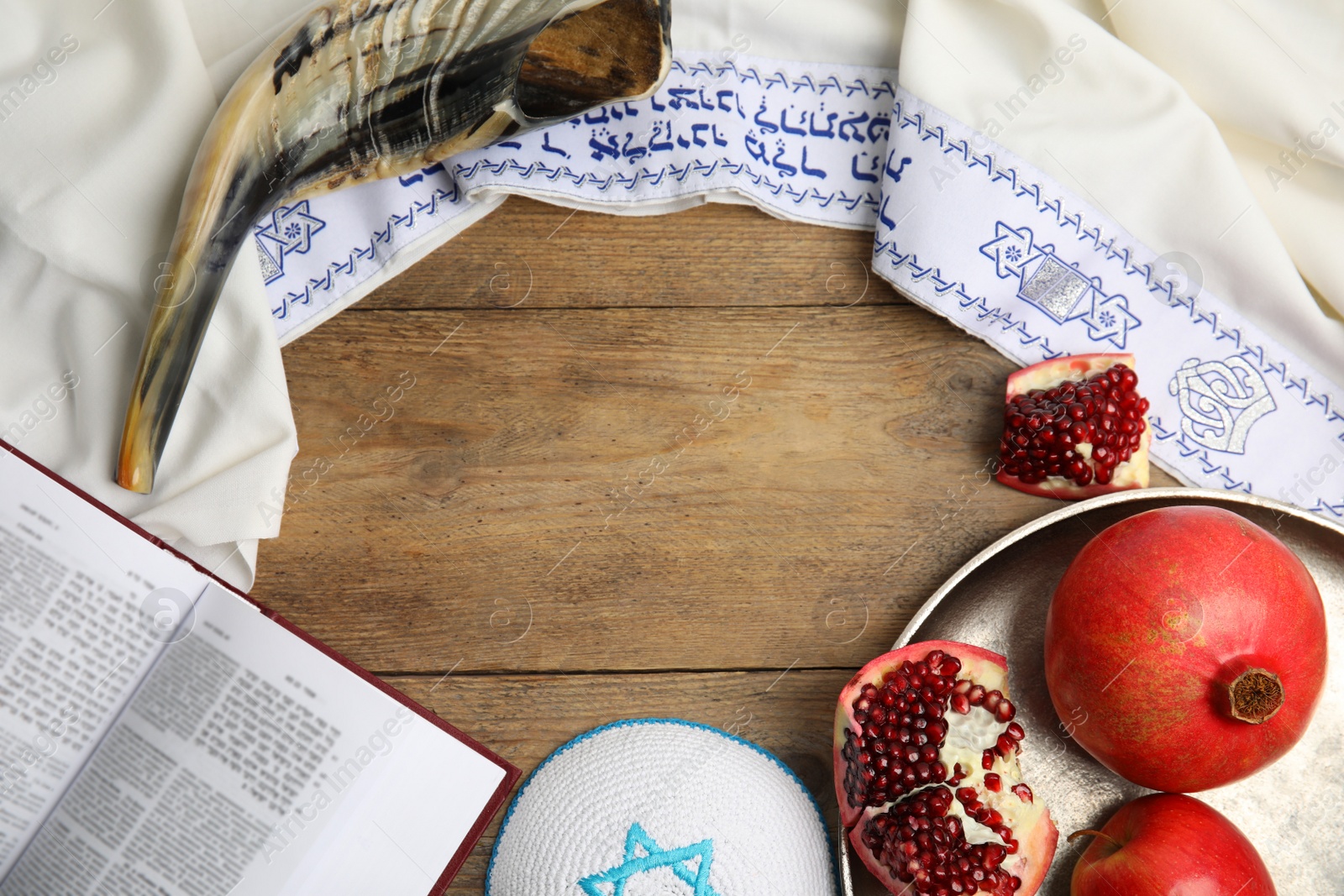 Photo of Frame of Rosh Hashanah holiday attributes on wooden table, flat lay. Space for text