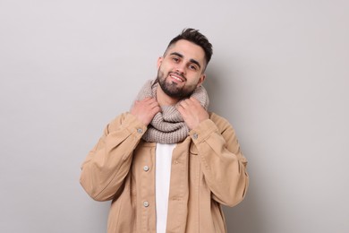 Photo of Smiling man in warm scarf on light grey background