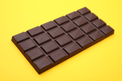 One tasty chocolate bar on yellow background