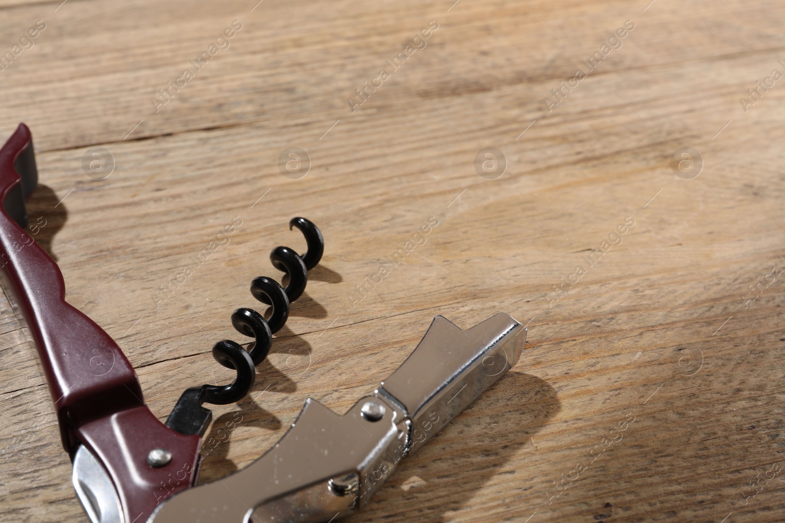 Photo of One corkscrew (sommelier knife) on wooden table. Space for text