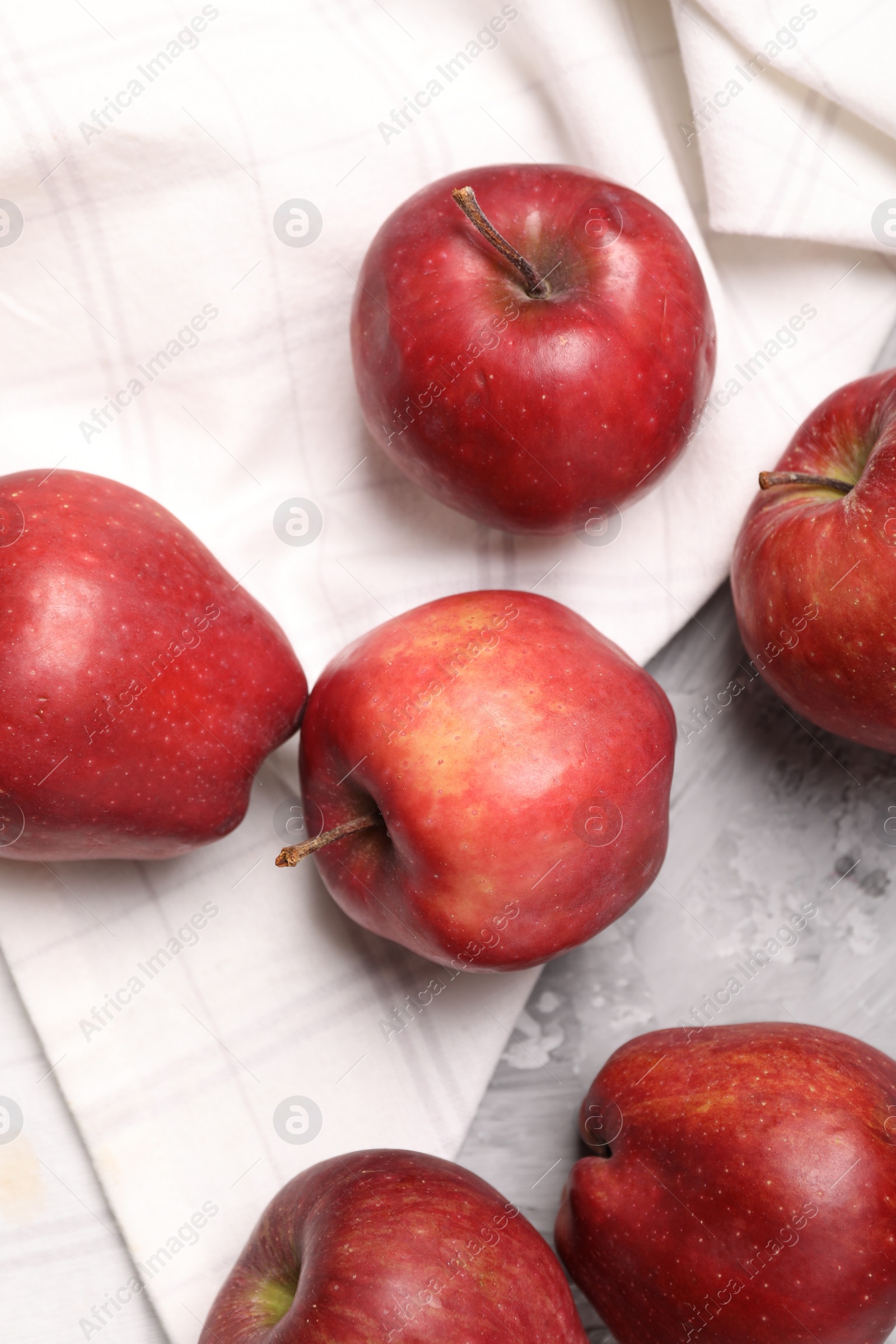 Photo of Fresh red apples on grey textured table, flat lay