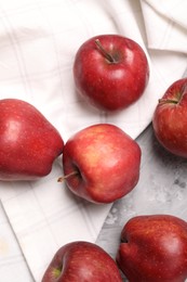 Photo of Fresh red apples on grey textured table, flat lay