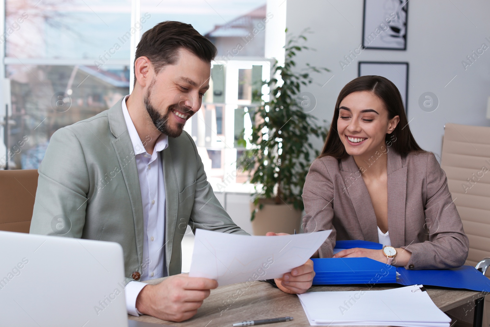 Photo of Office employees working with documents at table indoors