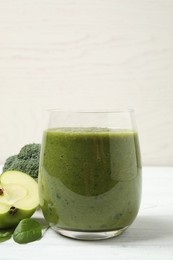Delicious fresh green juice on white wooden table