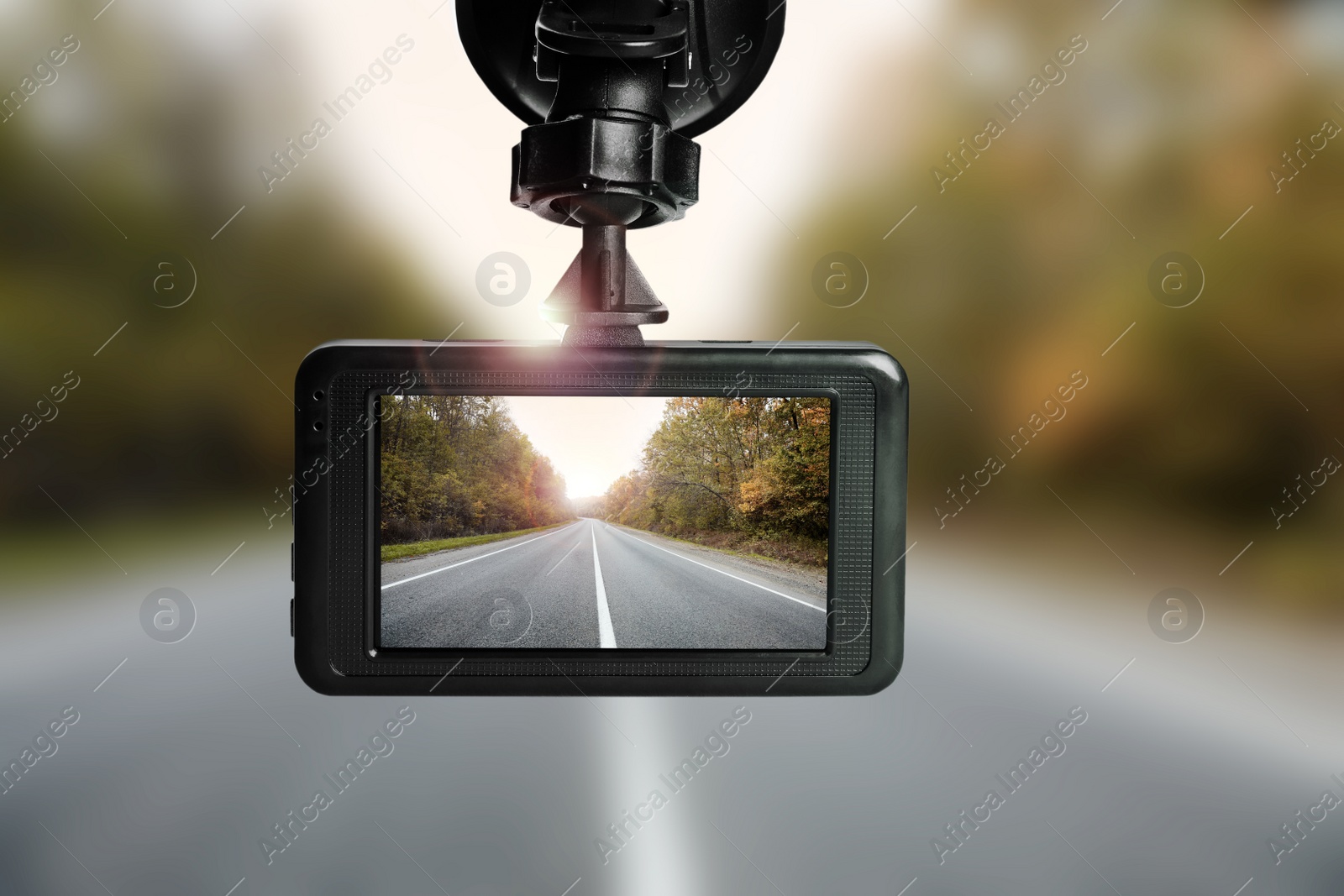 Image of Modern dashboard camera mounted in car, view of road during driving