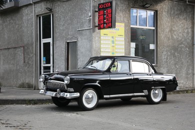 Beautiful vintage car parked near building on city street