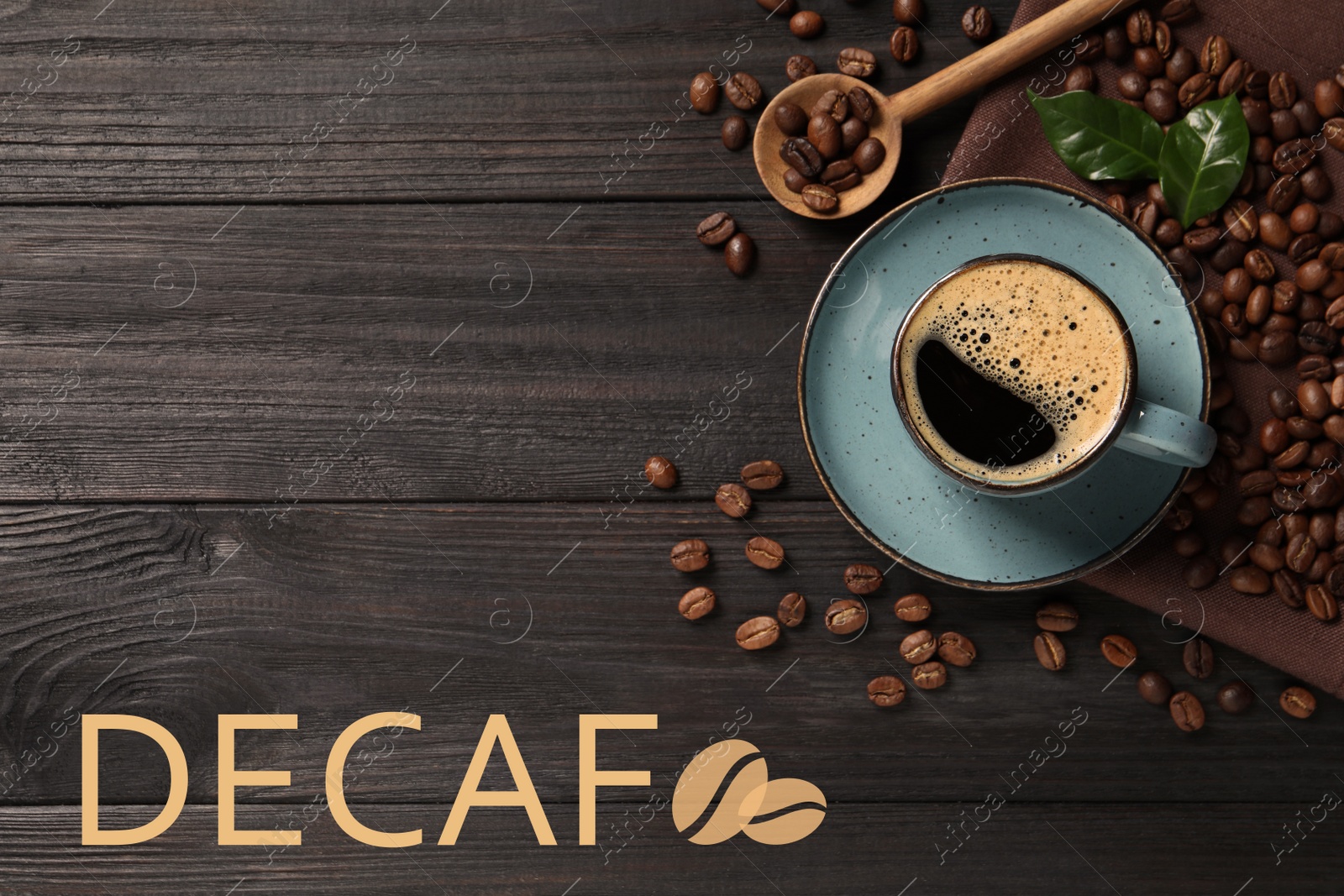 Image of Cup of aromatic decaf coffee and beans on black wooden table, flat lay