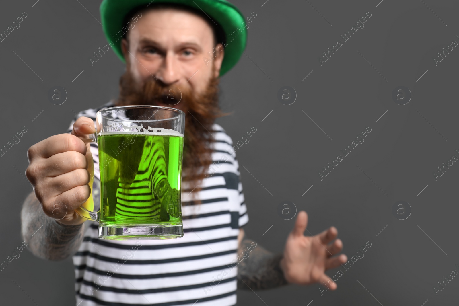 Photo of Bearded man with green beer on grey background. St. Patrick's Day celebration