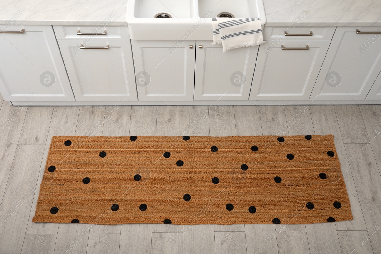 Photo of Stylish rug with dots on floor in kitchen, above view