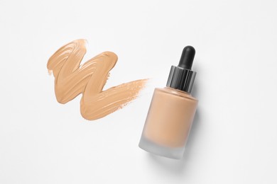 Photo of Liquid foundation and swatch on white background, top view