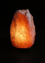 Photo of Himalayan salt lamp on black background