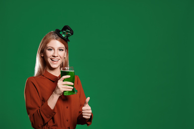 Photo of Young woman with green beer on color background, space for text. St. Patrick's Day celebration