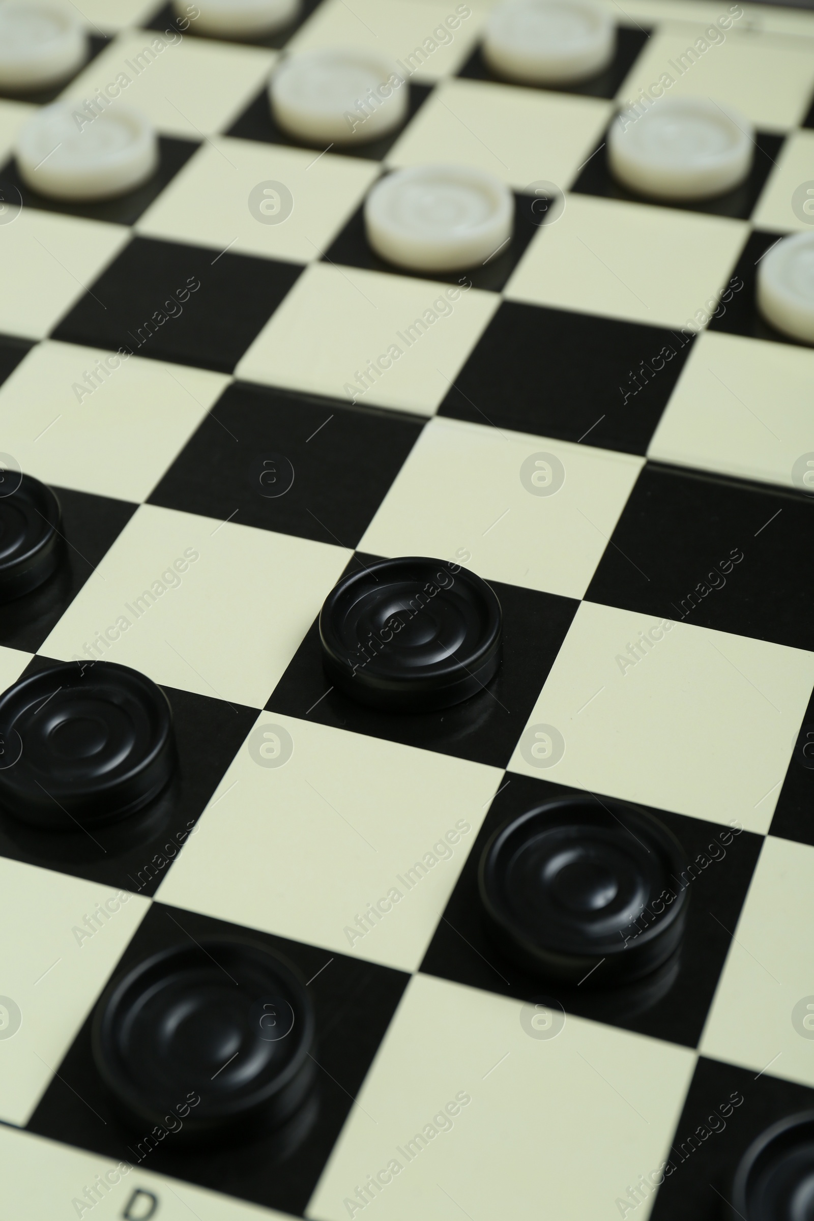 Photo of Checkerboard with game pieces as background, closeup