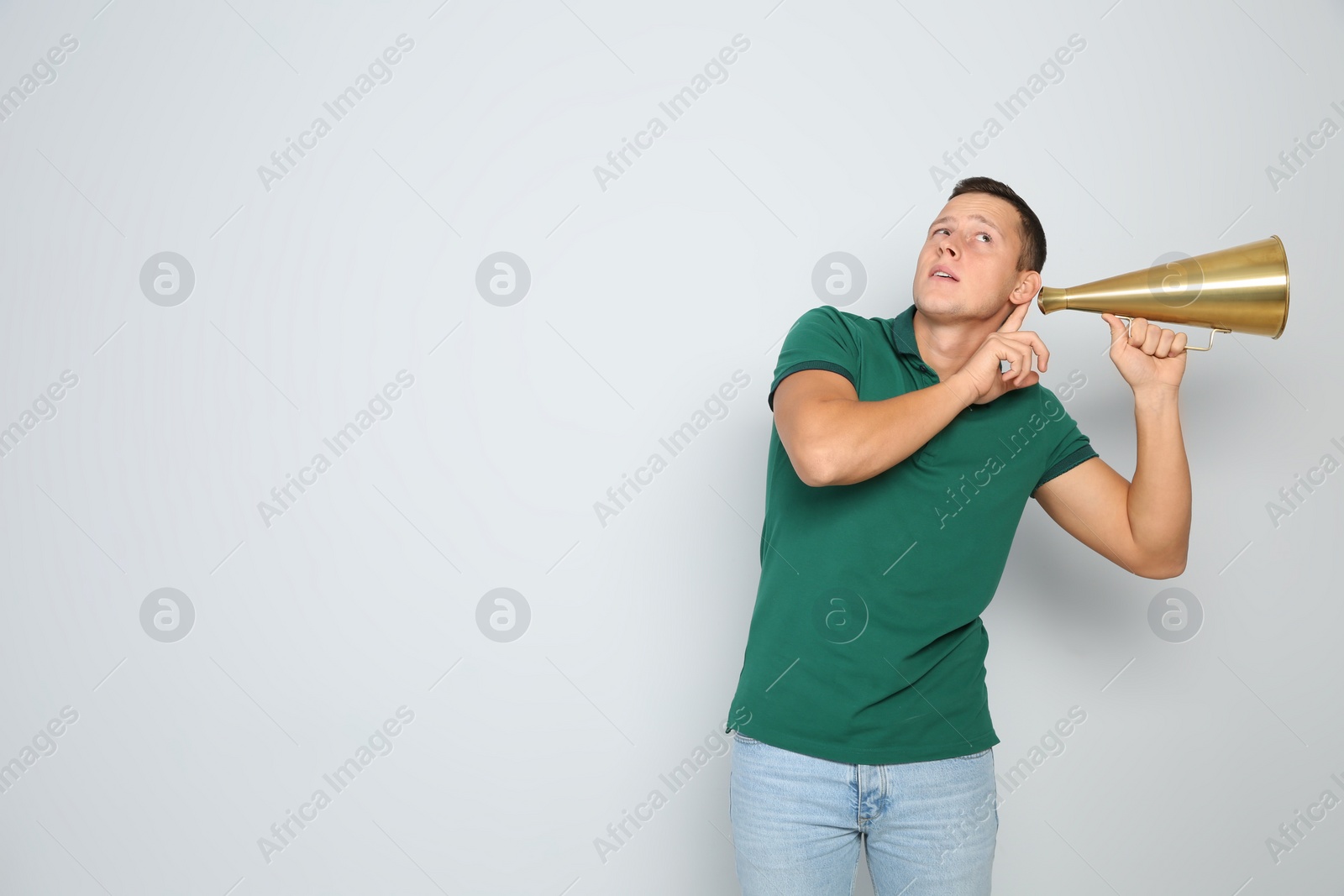 Photo of Young man with megaphone on white background. Space for text