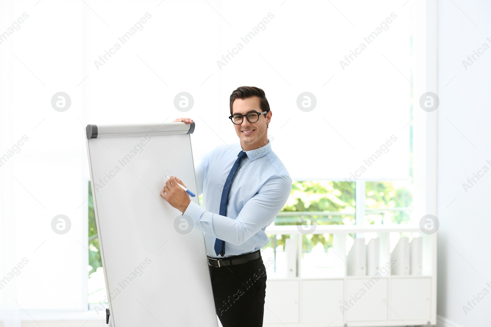 Photo of Professional business trainer near flip chart in office