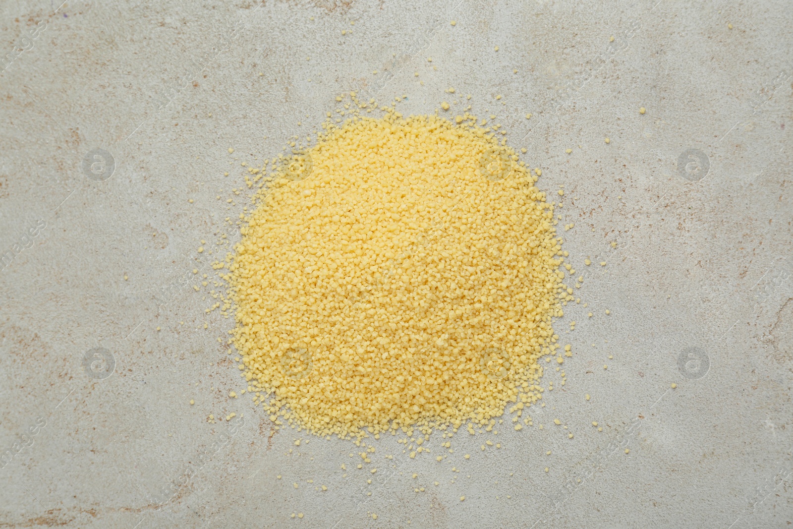 Photo of Heap of raw couscous on light table, top view