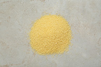 Photo of Heap of raw couscous on light table, top view