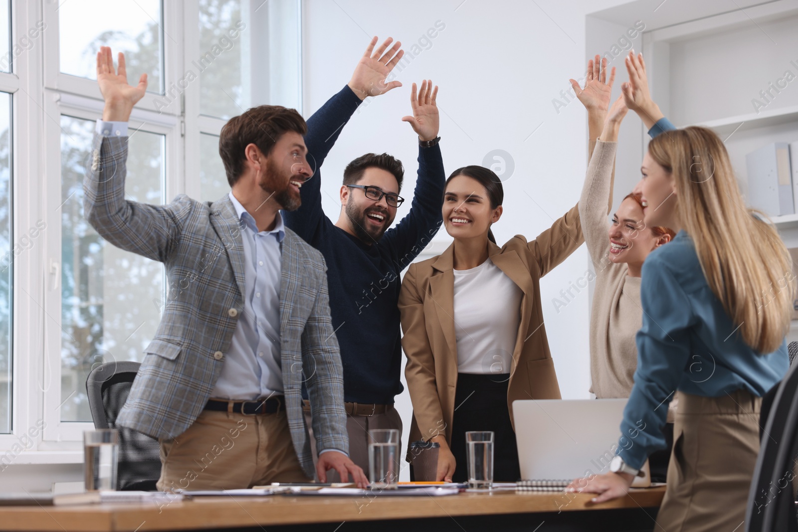 Photo of Team of employees celebrating success in office