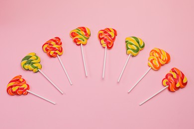 Sweet lollipops on pink background, flat lay