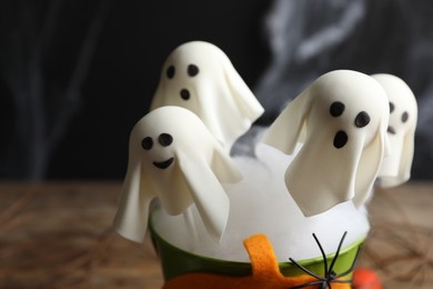Ghost shaped cake pops on dark background, closeup. Halloween treat