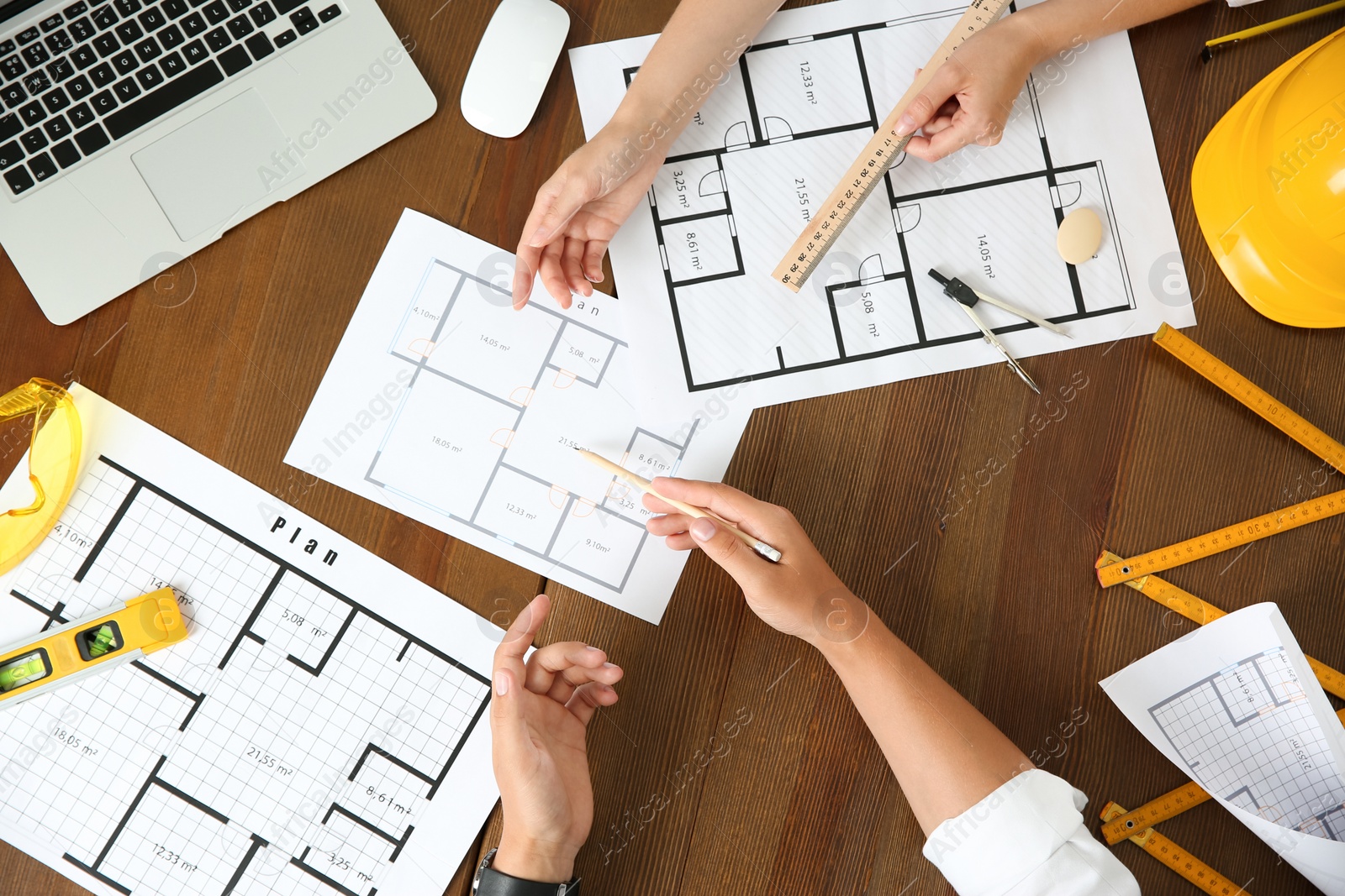 Photo of People working with construction drawings and tools  at wooden table, top view