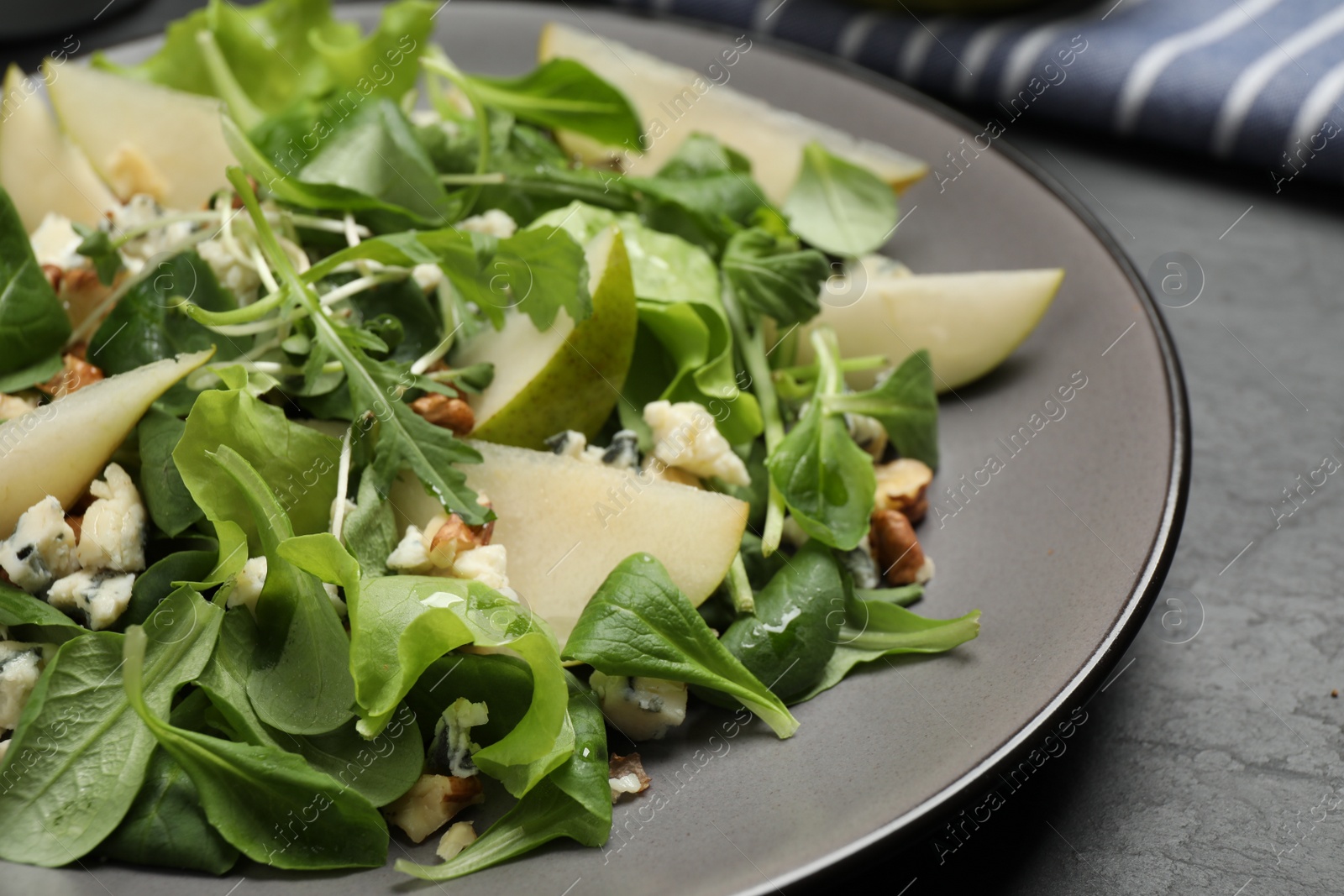 Photo of Tasty salad with pear slices on table, closeup