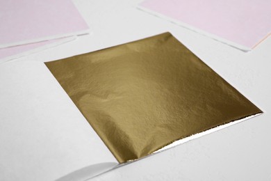Edible gold leaf sheet on white background, closeup