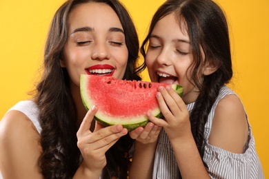 Photo of Happy girls with watermelon on yellow background