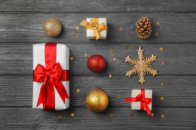 Photo of Flat lay Christmas composition with gift boxes and festive decor on wooden background