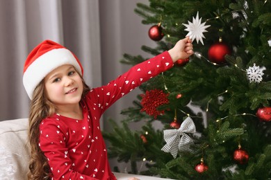 Photo of Happy girl near Christmas tree at home