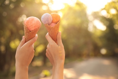 Photo of Women with ice cream spending time together outdoors, closeup
