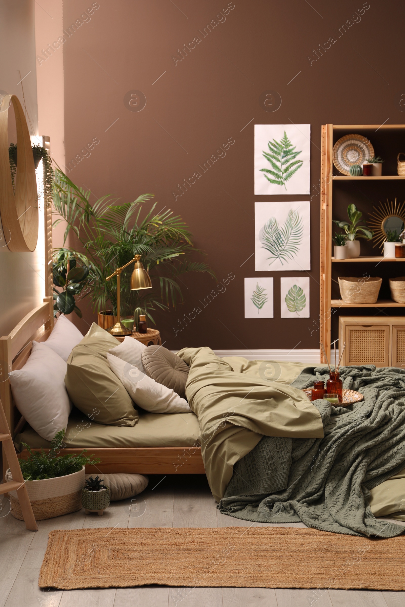 Photo of Stylish interior with large comfortable bed and potted plants