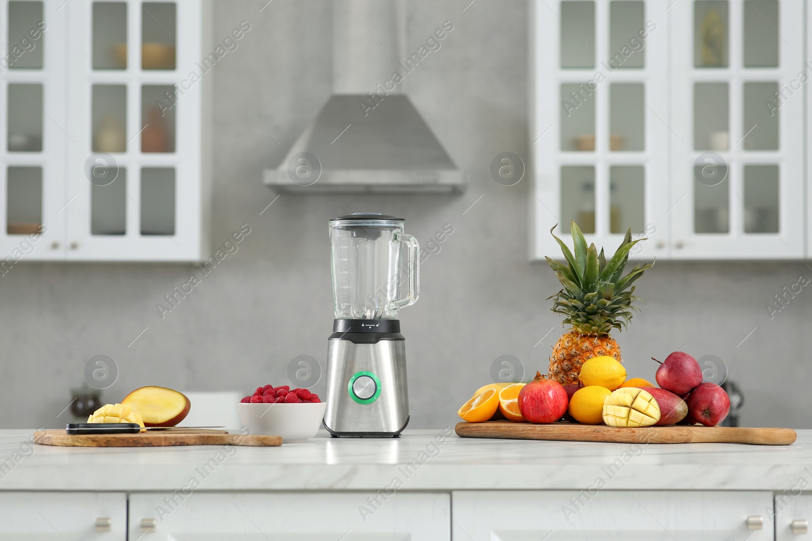 Photo of Blender and smoothie ingredients on white marble countertop in kitchen