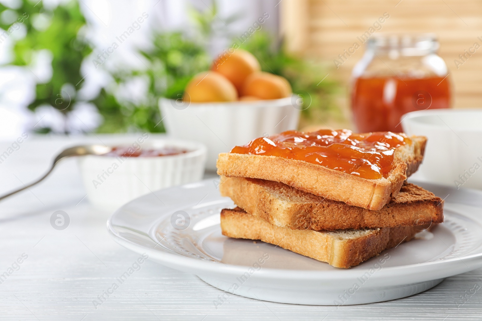 Photo of Bread with tasty apricot jam on plate